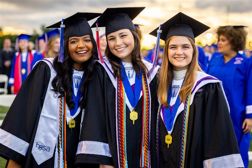 Students in blue robes graduate